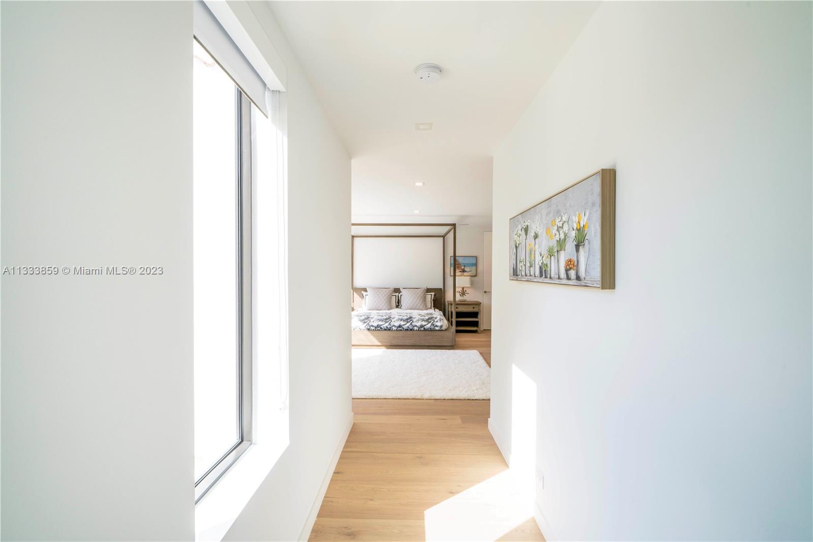 5334 Pine Tree Drive Miami Beach, FL 33140 - Photo 13 of 42 a view of a hallway with wooden floor and a living room
