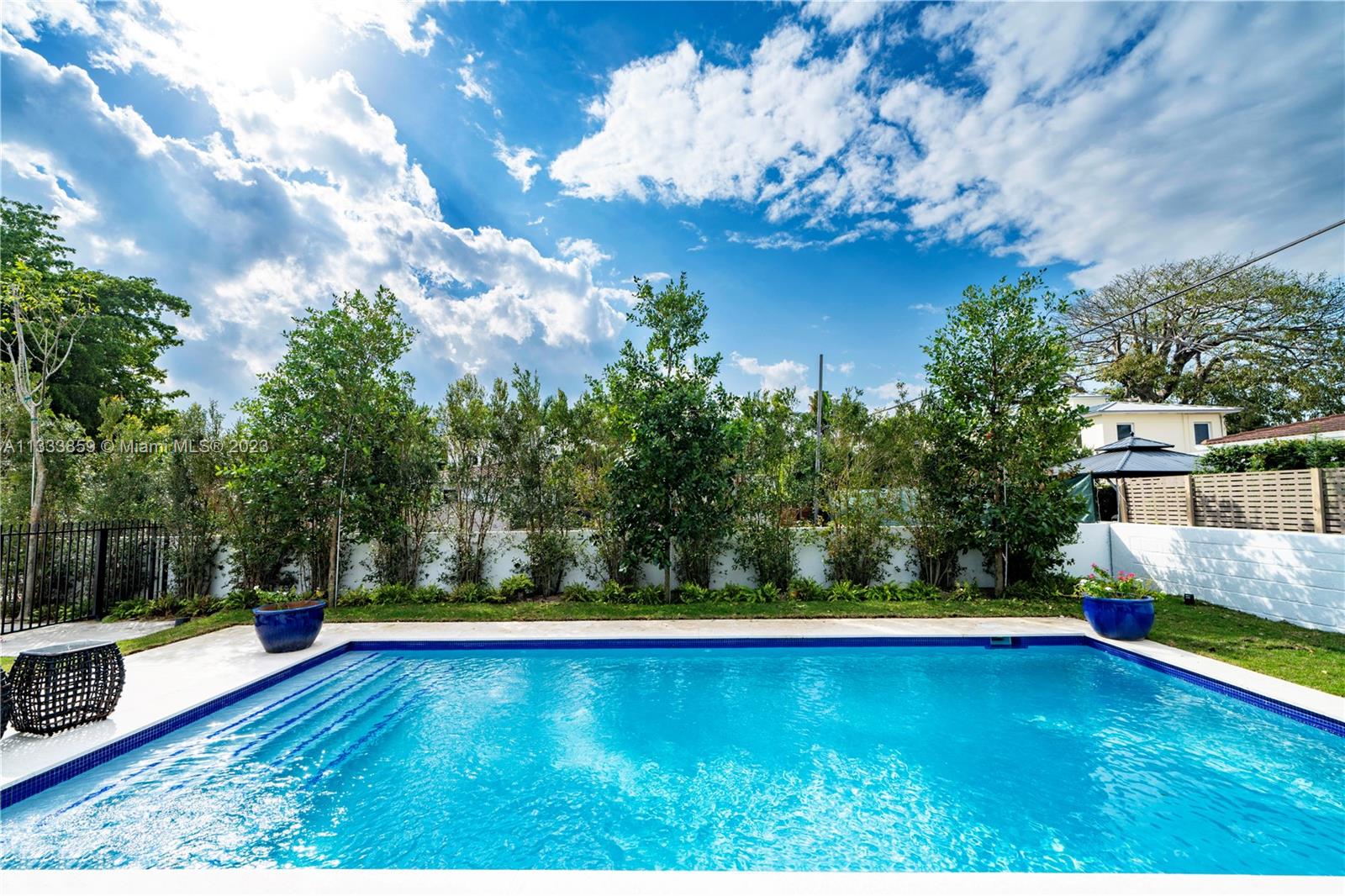 5334 Pine Tree Drive Miami Beach, FL 33140 - Photo 21 of 42 a view of a yard with an ocean and trees in the background