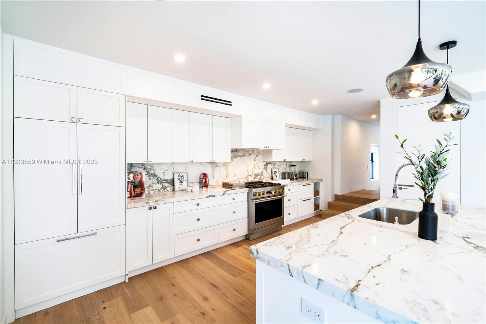 5334 Pine Tree Drive Miami Beach, FL 33140 - Photo 5 of 42 a kitchen with white cabinets and white appliances