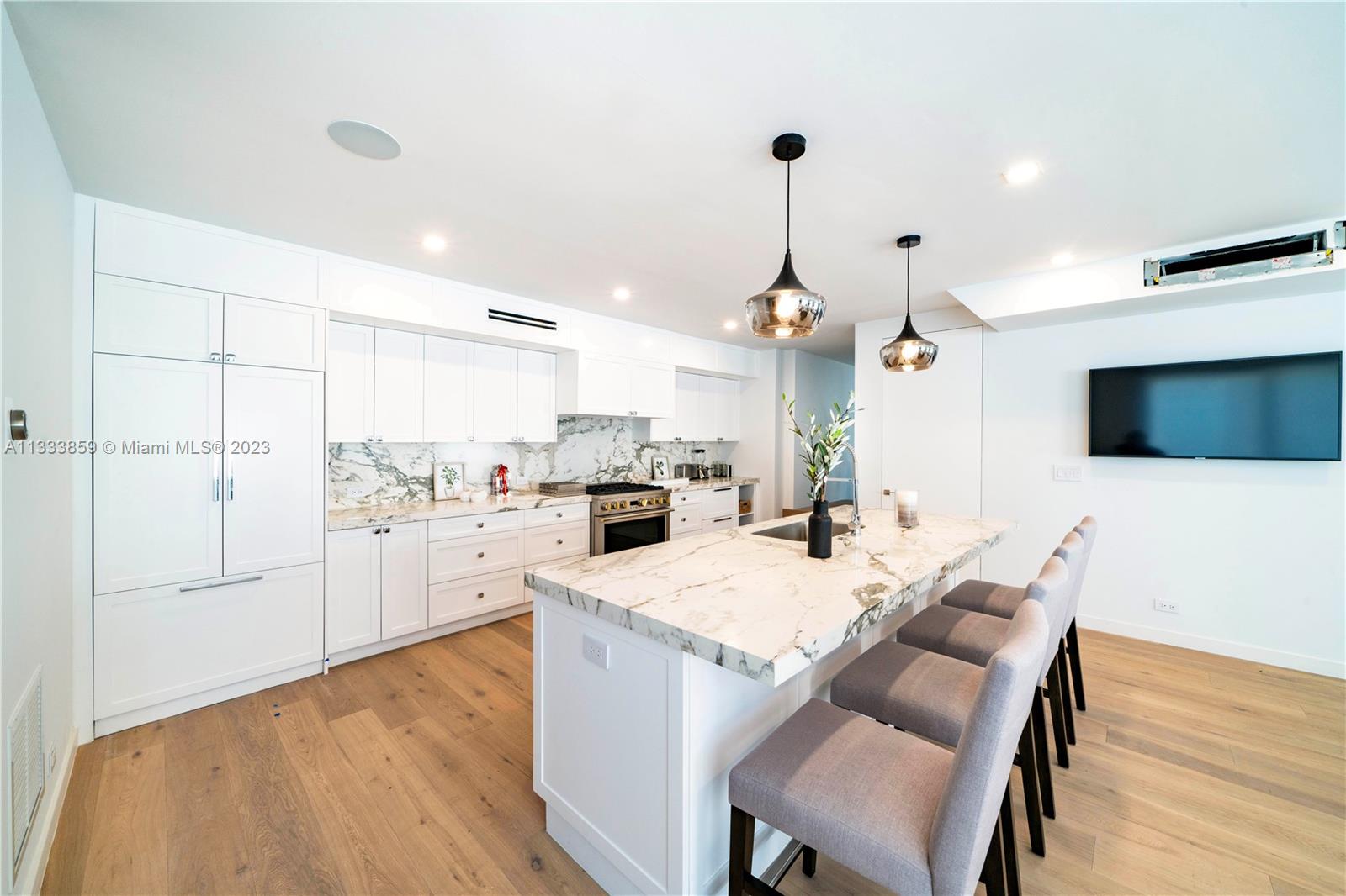 5334 Pine Tree Drive Miami Beach, FL 33140 - Photo 6 of 42 a open kitchen with white cabinets and stainless steel appliances