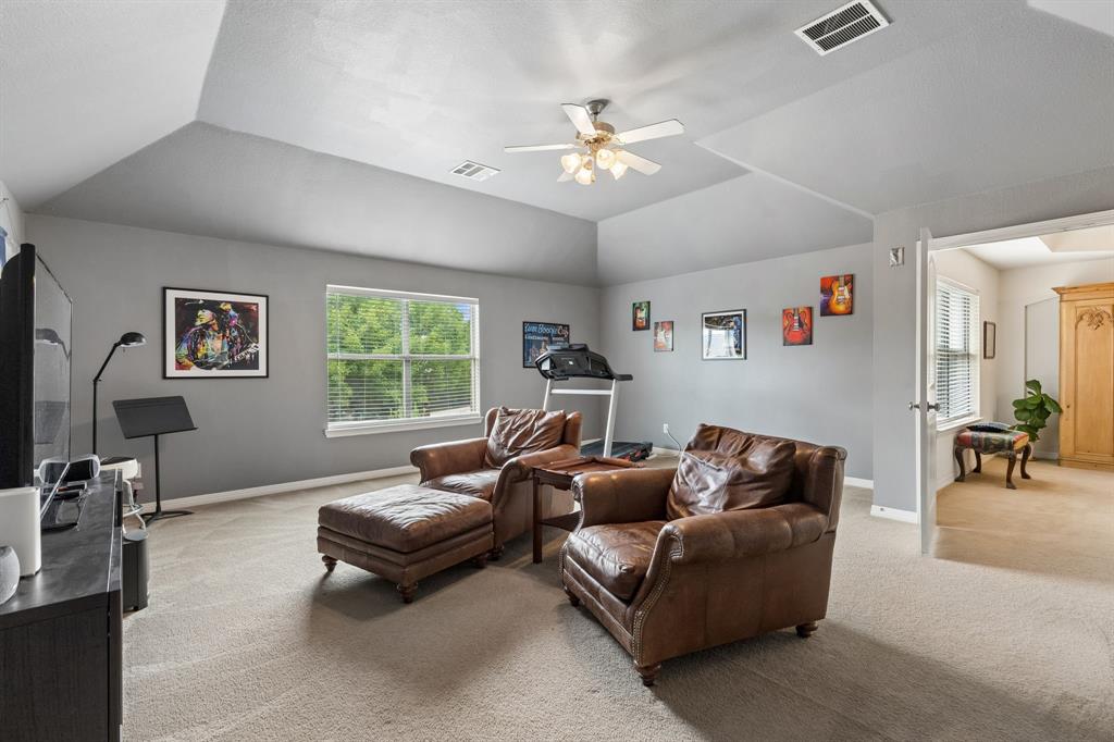 960 Remuda Road Frisco, TX 75033 - Photo 23 of 39 Spacious room featuring vaulted ceilings, a ceiling fan, carpeted flooring, and a large window providing natural light