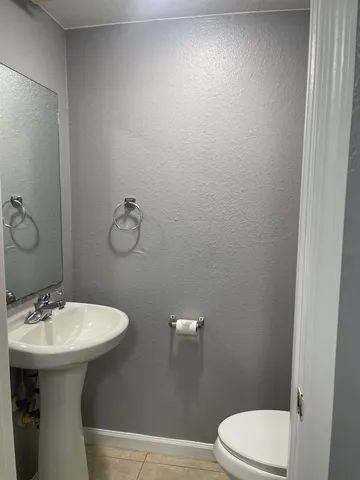 a bathroom with a sink a toilet and mirror