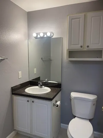 a bathroom with a toilet sink and mirror
