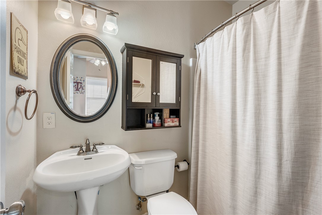114 Lynn Drive Bryan, TX 77801 - Photo 18 of 31 a bathroom with a toilet sink and mirror