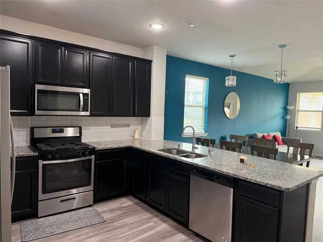 a kitchen with a sink stove microwave and cabinets