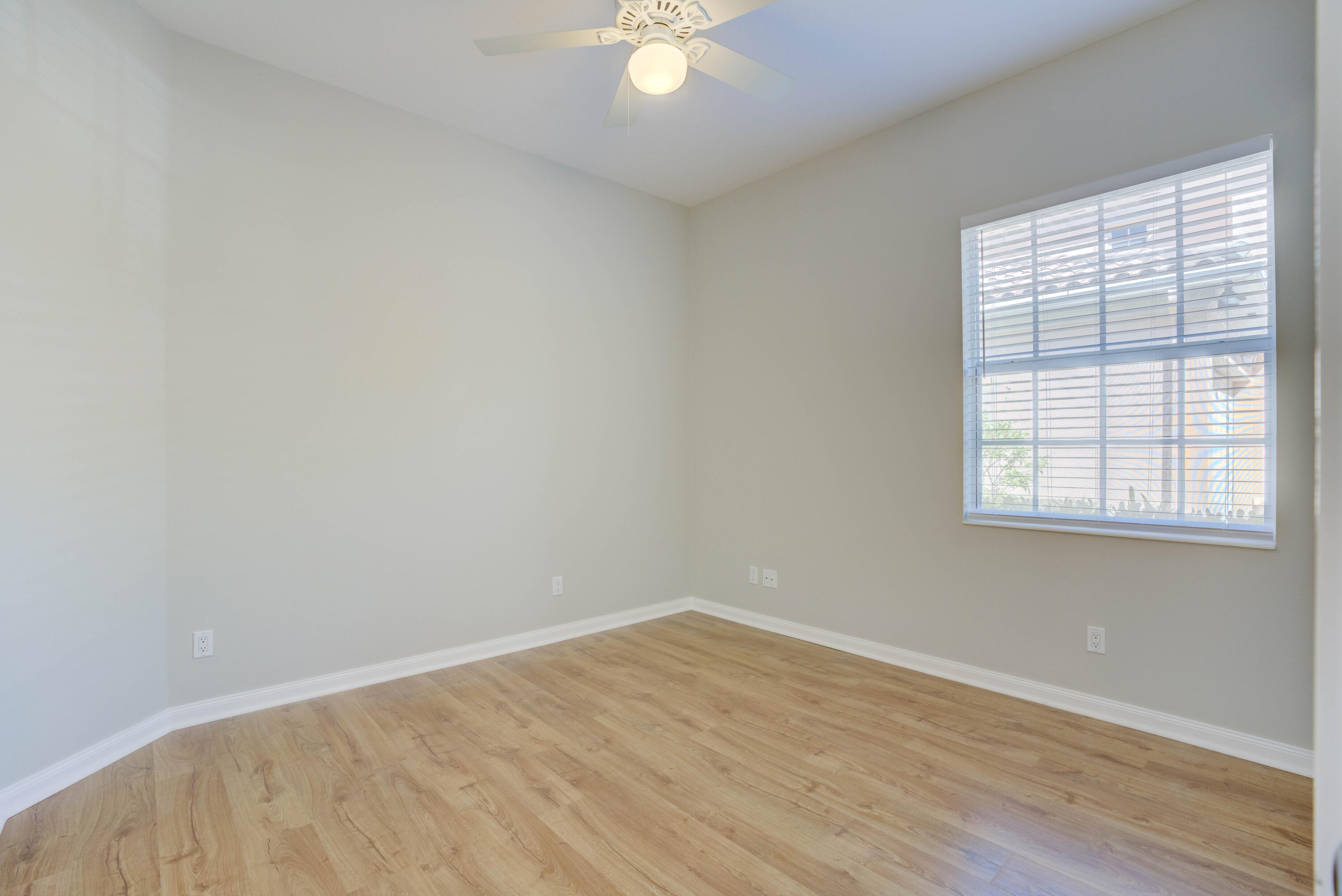 256 San Remo Drive Jupiter, FL 33458 - Photo 24 of 46 wooden floor in an empty room with a window