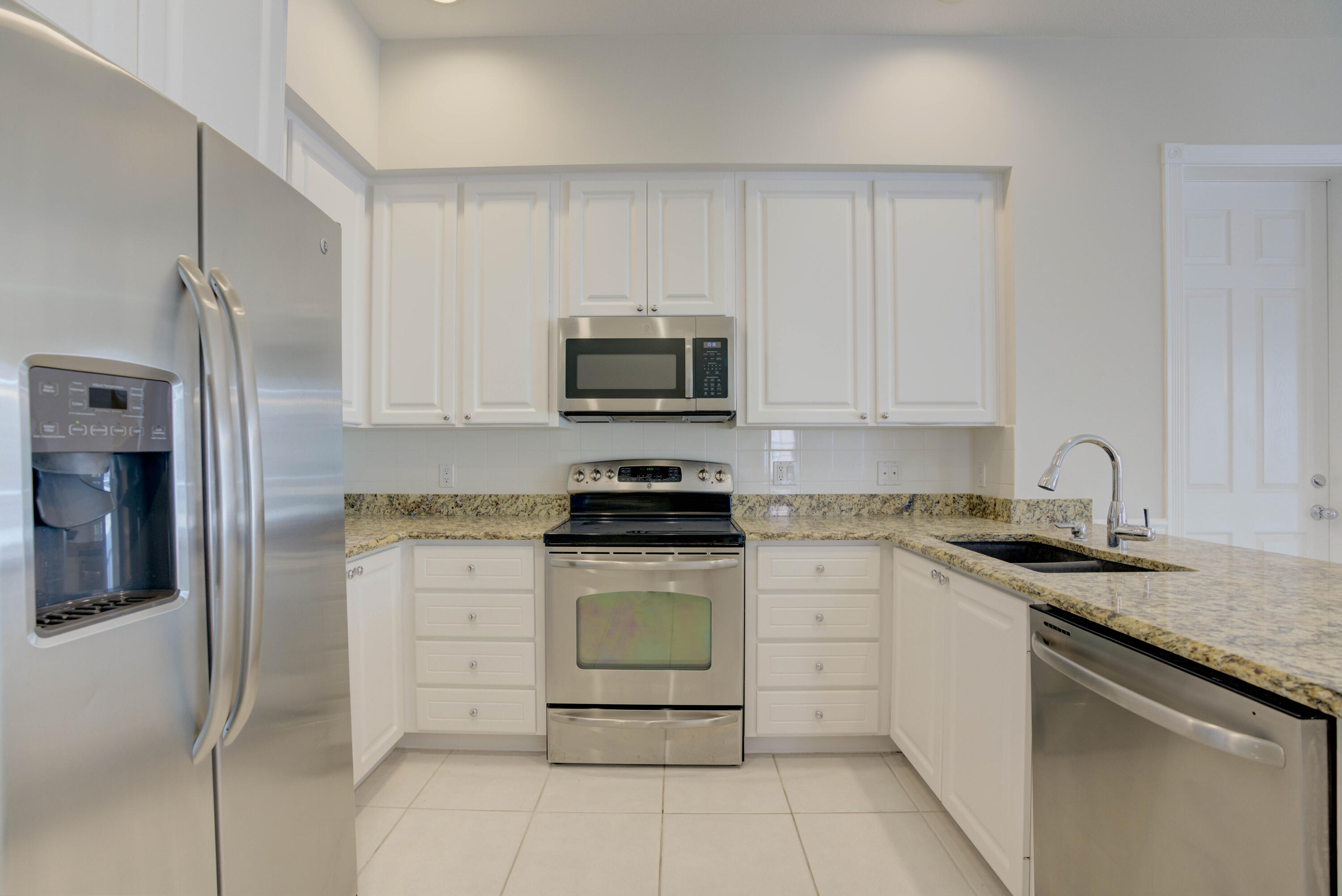 256 San Remo Drive Jupiter, FL 33458 - Photo 26 of 46 a kitchen with granite countertop a stove sink and refrigerator