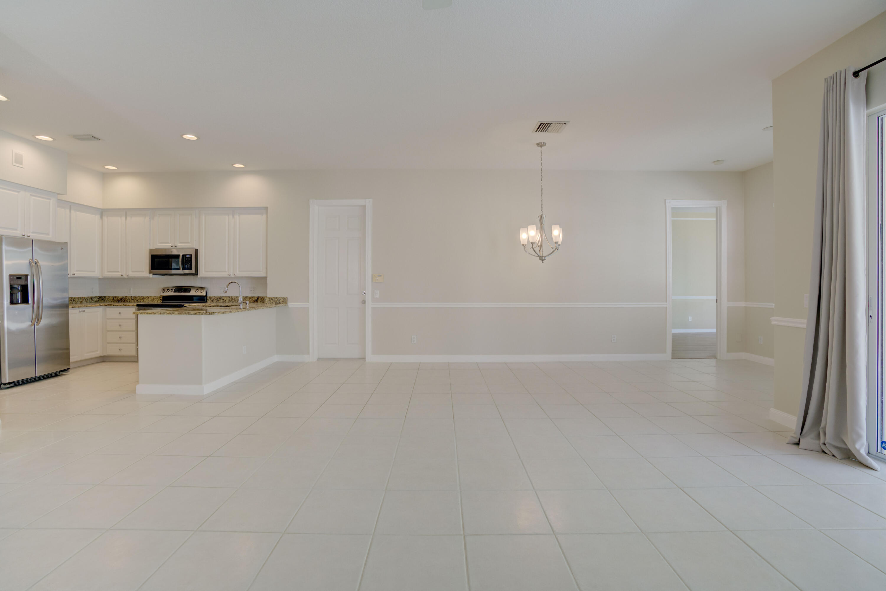 256 San Remo Drive Jupiter, FL 33458 - Photo 31 of 46 a view of a kitchen with refrigerator and white cabinets