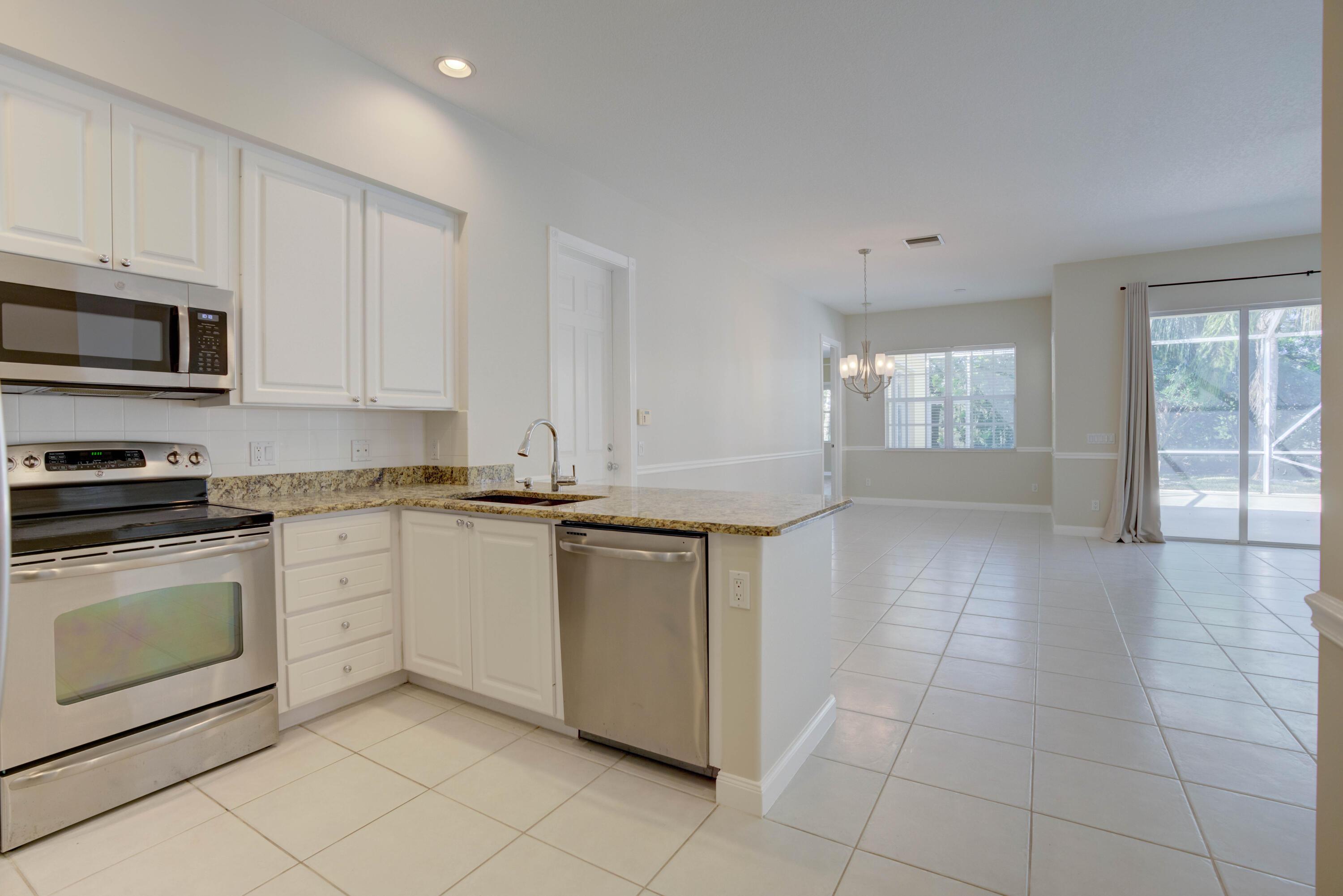 256 San Remo Drive Jupiter, FL 33458 - Photo 5 of 46 a kitchen with stainless steel appliances granite countertop a stove a sink and a microwave