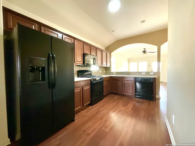 a kitchen with stainless steel appliances granite countertop a refrigerator a sink and a stove