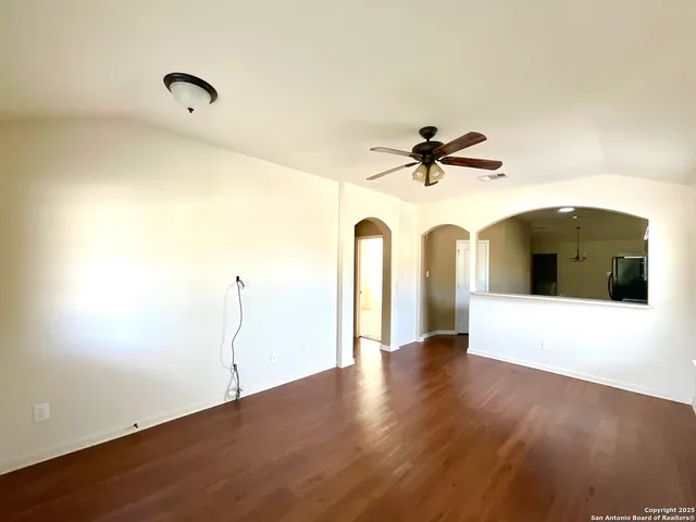 a view of a white building with wooden floor and a ceiling fan