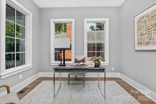 a living room with furniture and two window