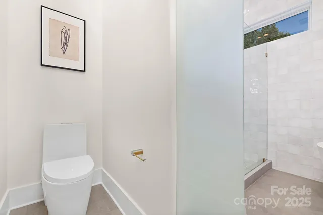 a white toilet sitting next to a shower