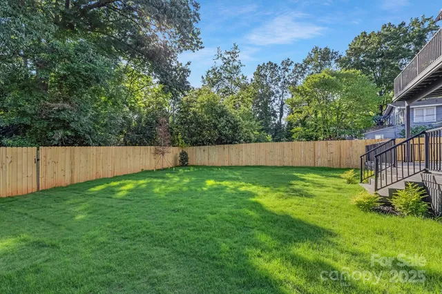 a view of a backyard with a fence and plants