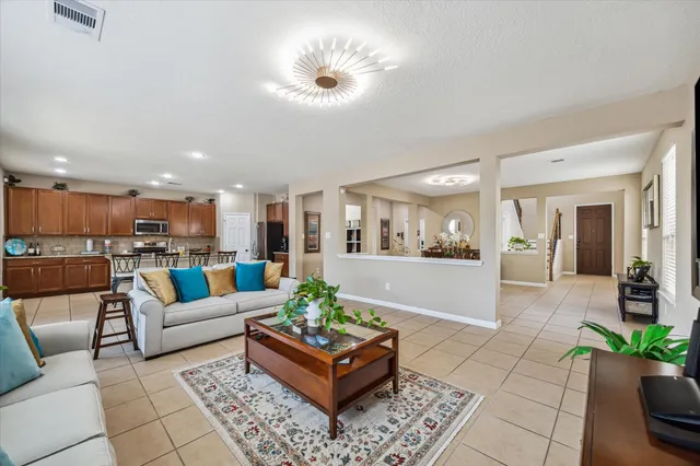 a living room with furniture and a view of kitchen
