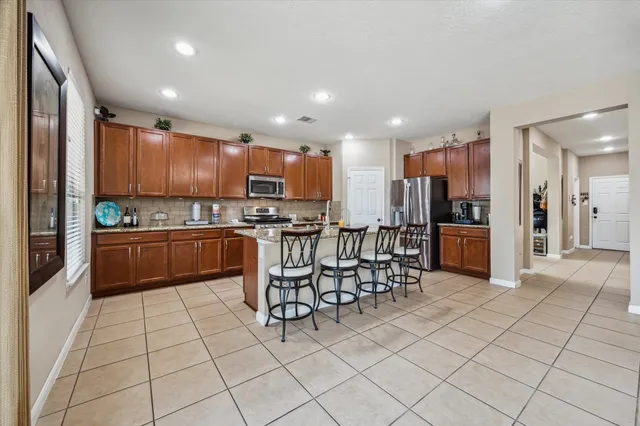 a kitchen with stainless steel appliances a refrigerator and a stove top oven