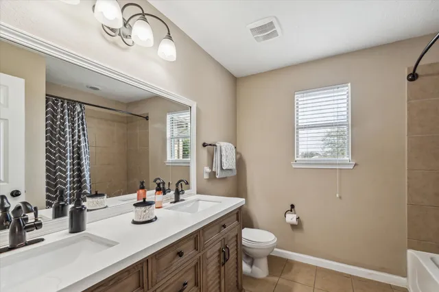 a bathroom with a double vanity sink toilet and a mirror