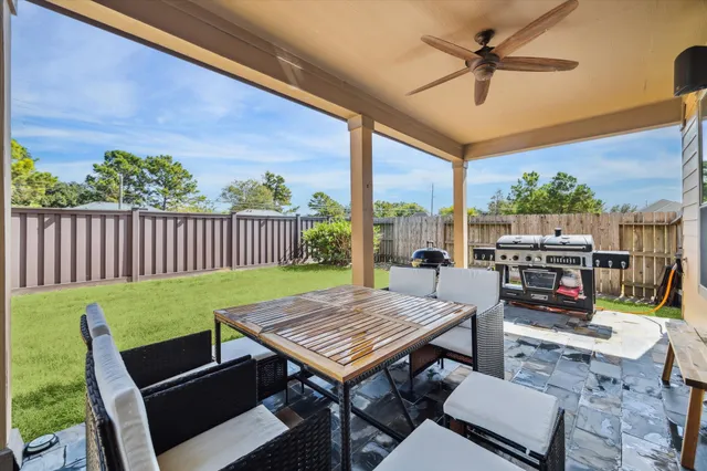 a view of a patio with a dining table and chairs with wooden floor