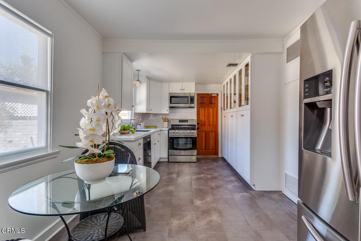 602 Atchison Street Pasadena, CA 91104 - Photo 13 of 34 a dining room with furniture a chandelier and kitchen view