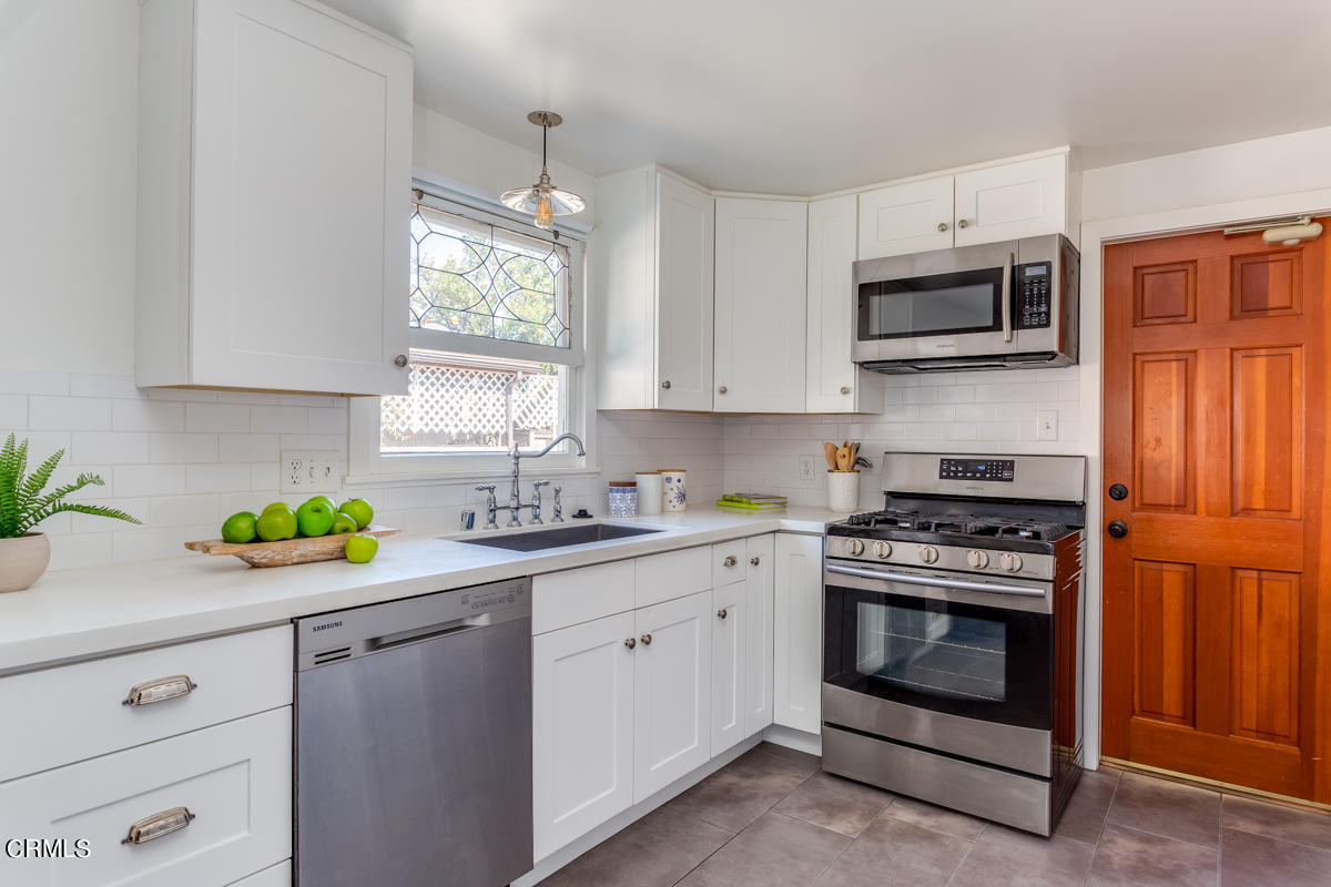 602 Atchison Street Pasadena, CA 91104 - Photo 14 of 34 a kitchen with stainless steel appliances white cabinets and a stove top oven