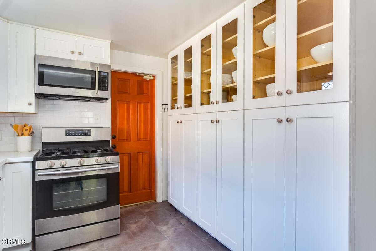 602 Atchison Street Pasadena, CA 91104 - Photo 15 of 34 a kitchen with stainless steel appliances granite countertop white cabinets and a stove top oven