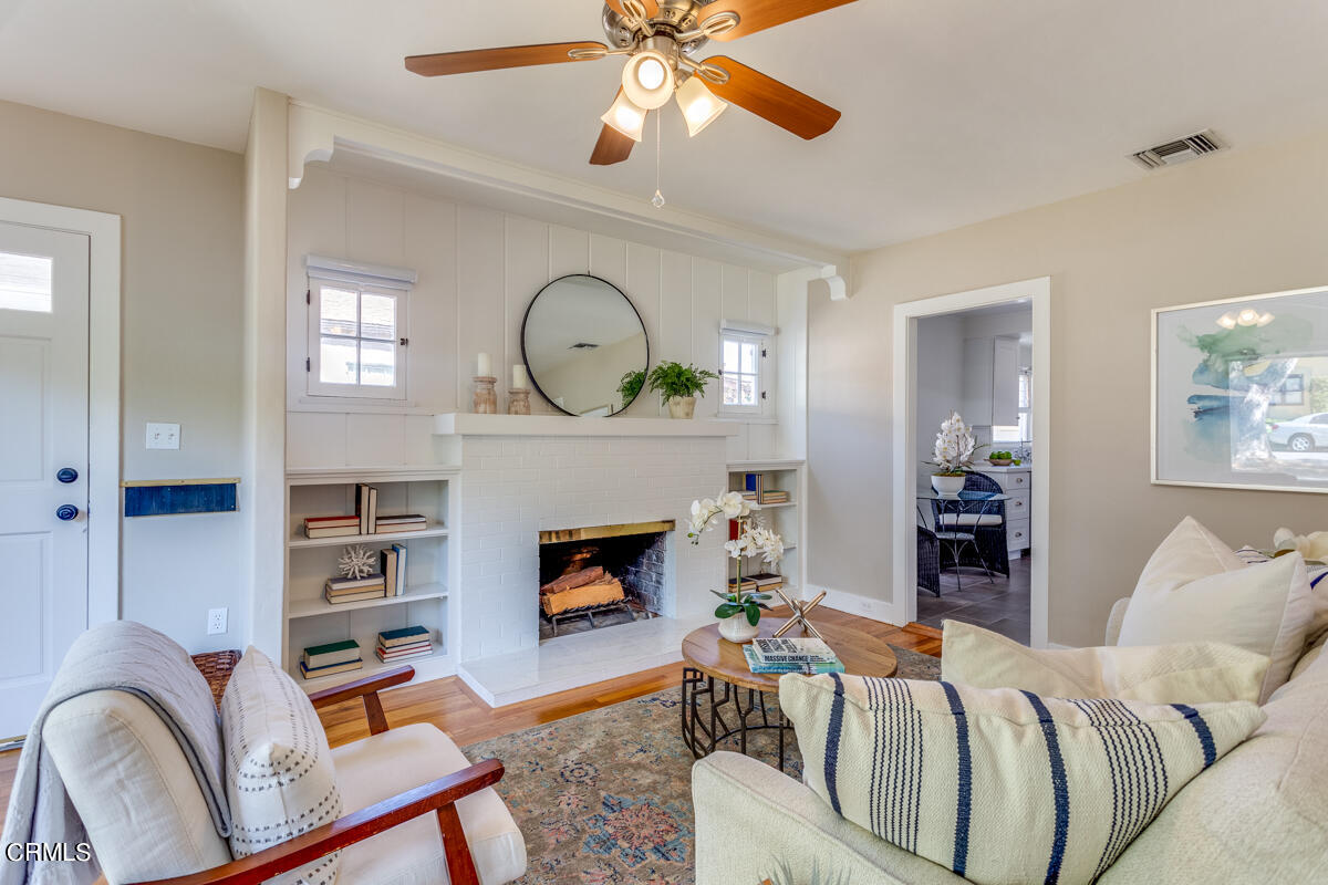 602 Atchison Street Pasadena, CA 91104 - Photo 9 of 34 a living room with furniture a fireplace and a chandelier