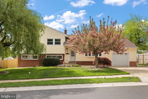 a front view of a house with a yard and trees