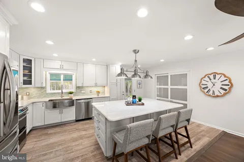 a kitchen with a dining table chairs and refrigerator