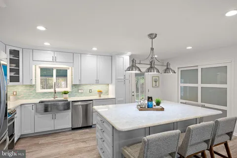 a kitchen with a stove a sink a dining table and chairs