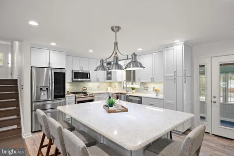 a kitchen with refrigerator cabinets dining table and chairs