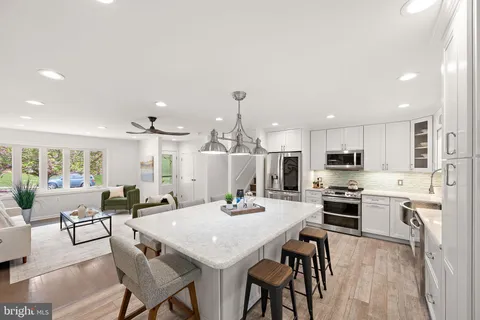 a view of a dining room with furniture a kitchen and chandelier