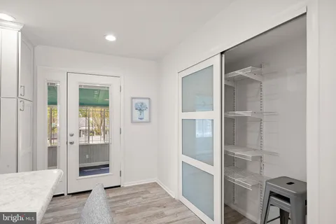 a view of a livingroom with wooden floor and a bathroom space