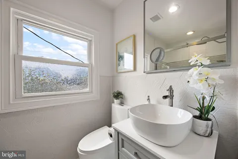 a bathroom with a toilet a sink and a window