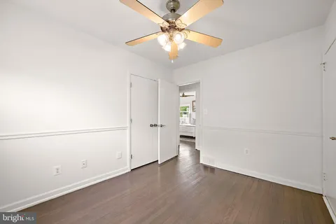 an empty room with a ceiling fan and wooden floor