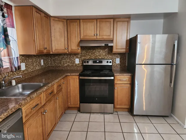 a kitchen with a refrigerator sink and cabinets