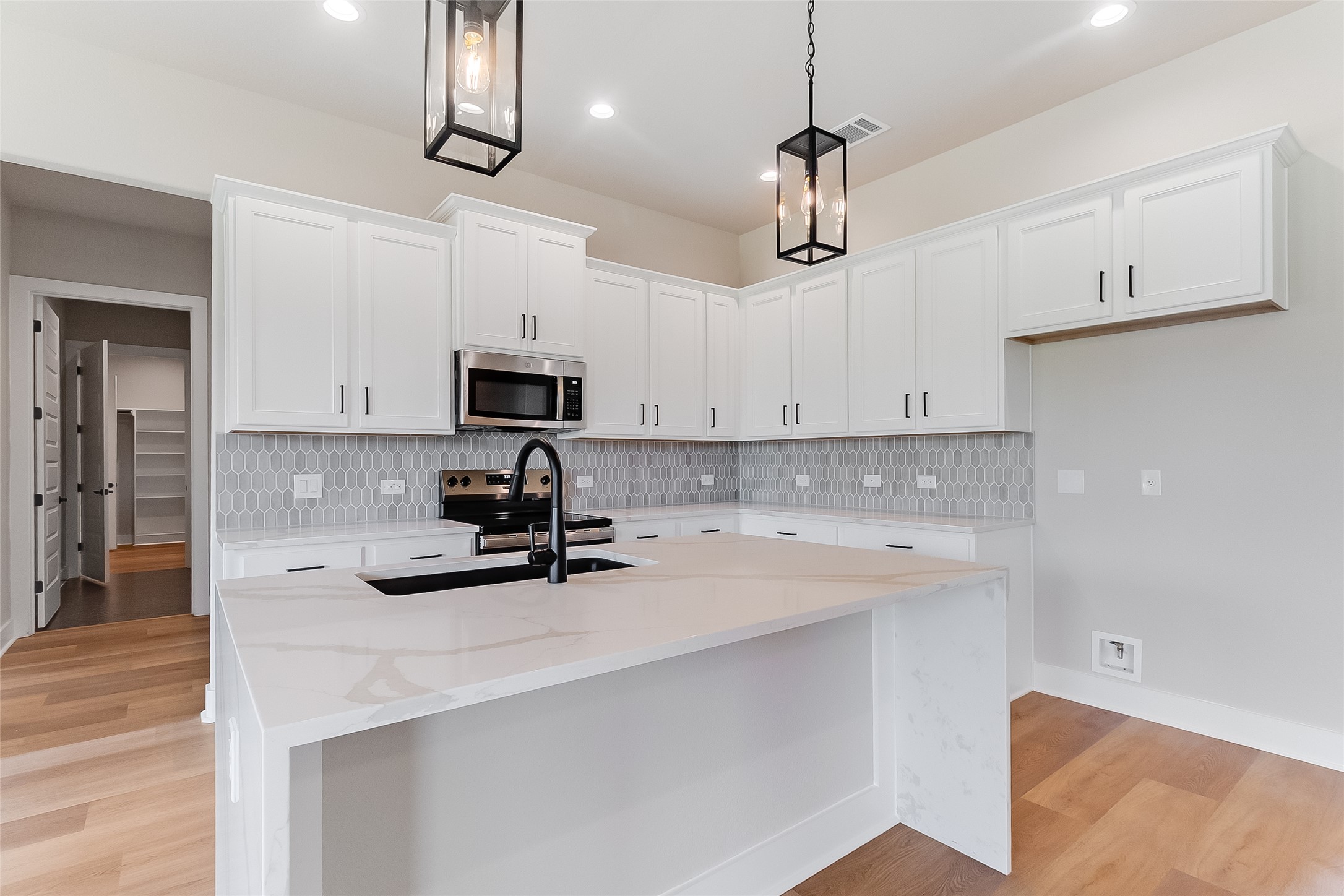 130 Draper Lane Bertram, TX 78605 - Photo 13 of 31 a kitchen with a sink a microwave and cabinets