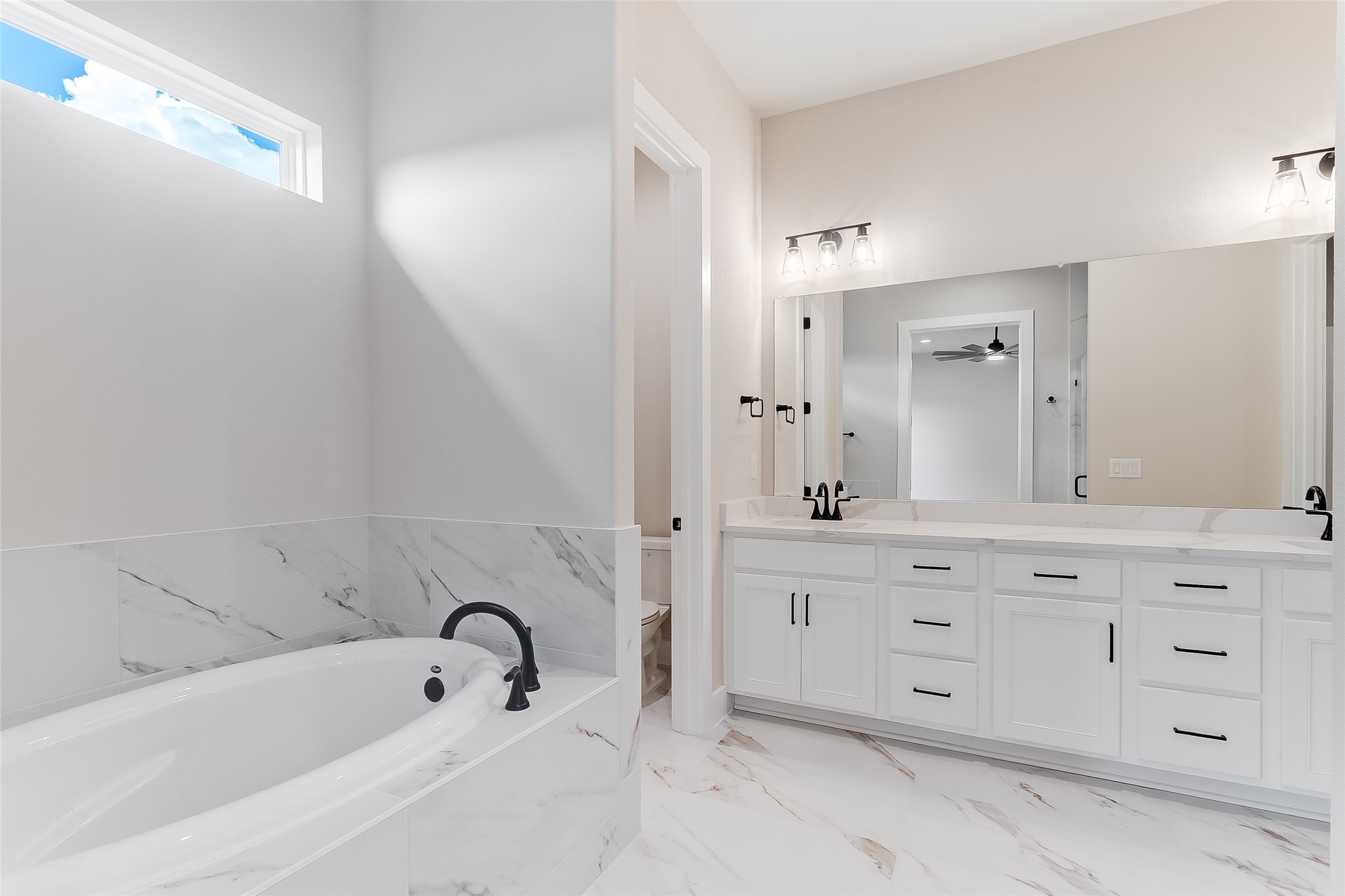 130 Draper Lane Bertram, TX 78605 - Photo 23 of 31 a bathroom with a bathtub sink vanity and mirror