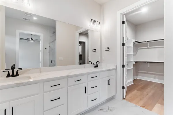 a bathroom with a double vanity sink mirror double and shower