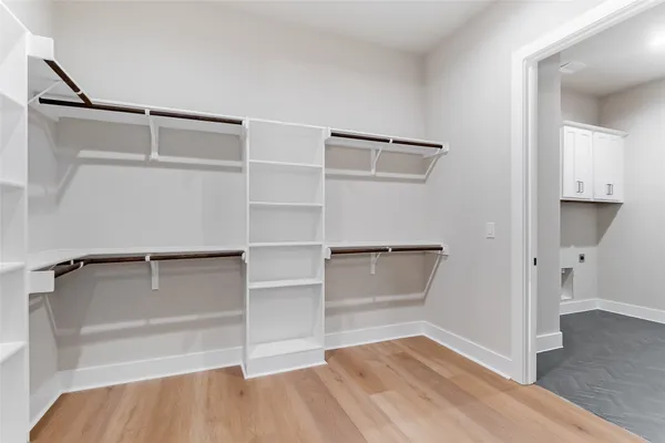 a view of walk in closet with empty racks