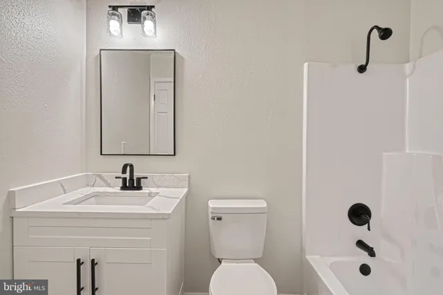 a view of a house with a yard and large tree