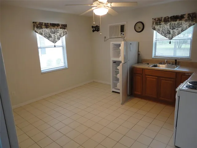 a kitchen with stainless steel appliances kitchen island granite countertop a refrigerator and a sink