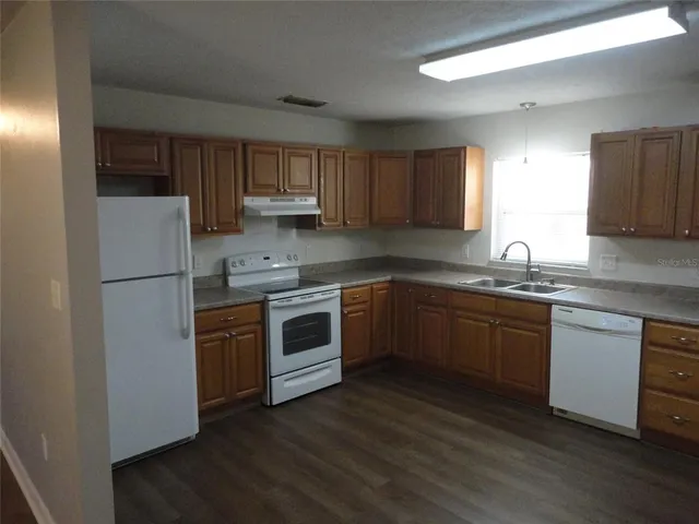 a kitchen with sink a microwave and cabinets