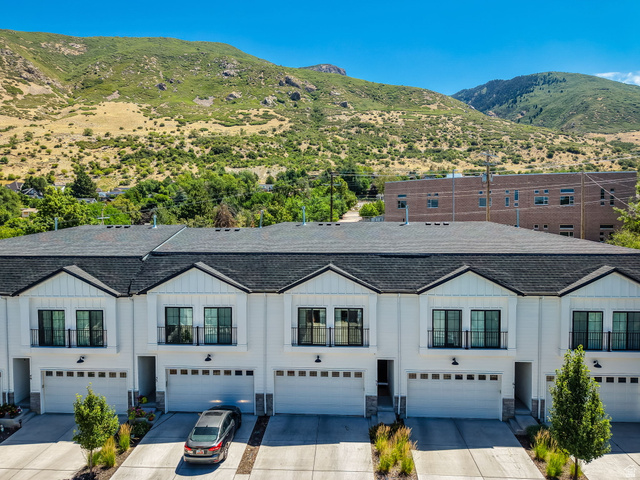 57 McCall Ln. Farmington, UT 84025 - Photo 35 of 36 Contemporary townhome facade featuring white siding, black-framed windows, and mountain views