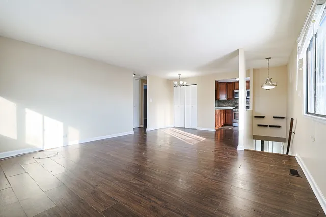 a view of a kitchen with a fridge and wooden floor