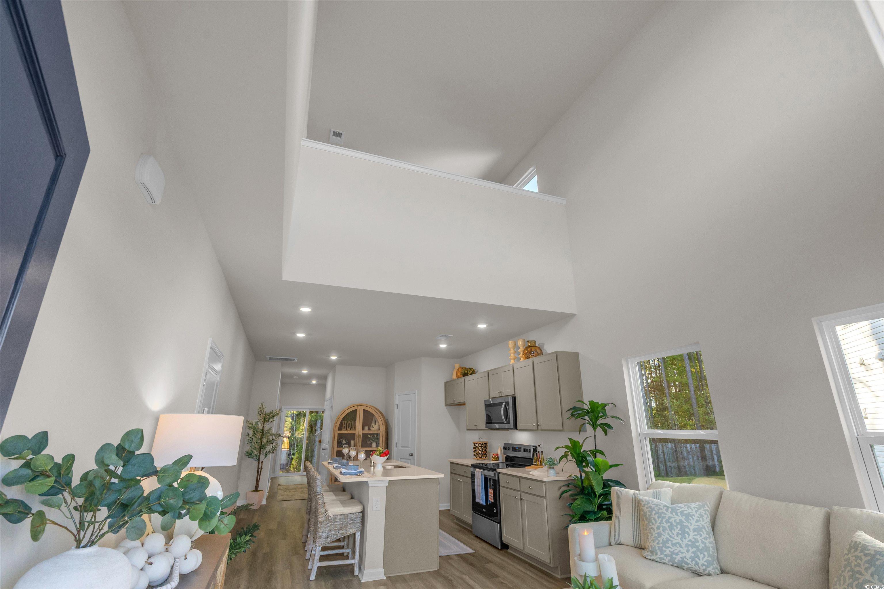 814 Palm Frond Way, Unit 42 Calabash, NC 28467 - Photo 12 of 31 Living room with light LVP floors and a high ceiling