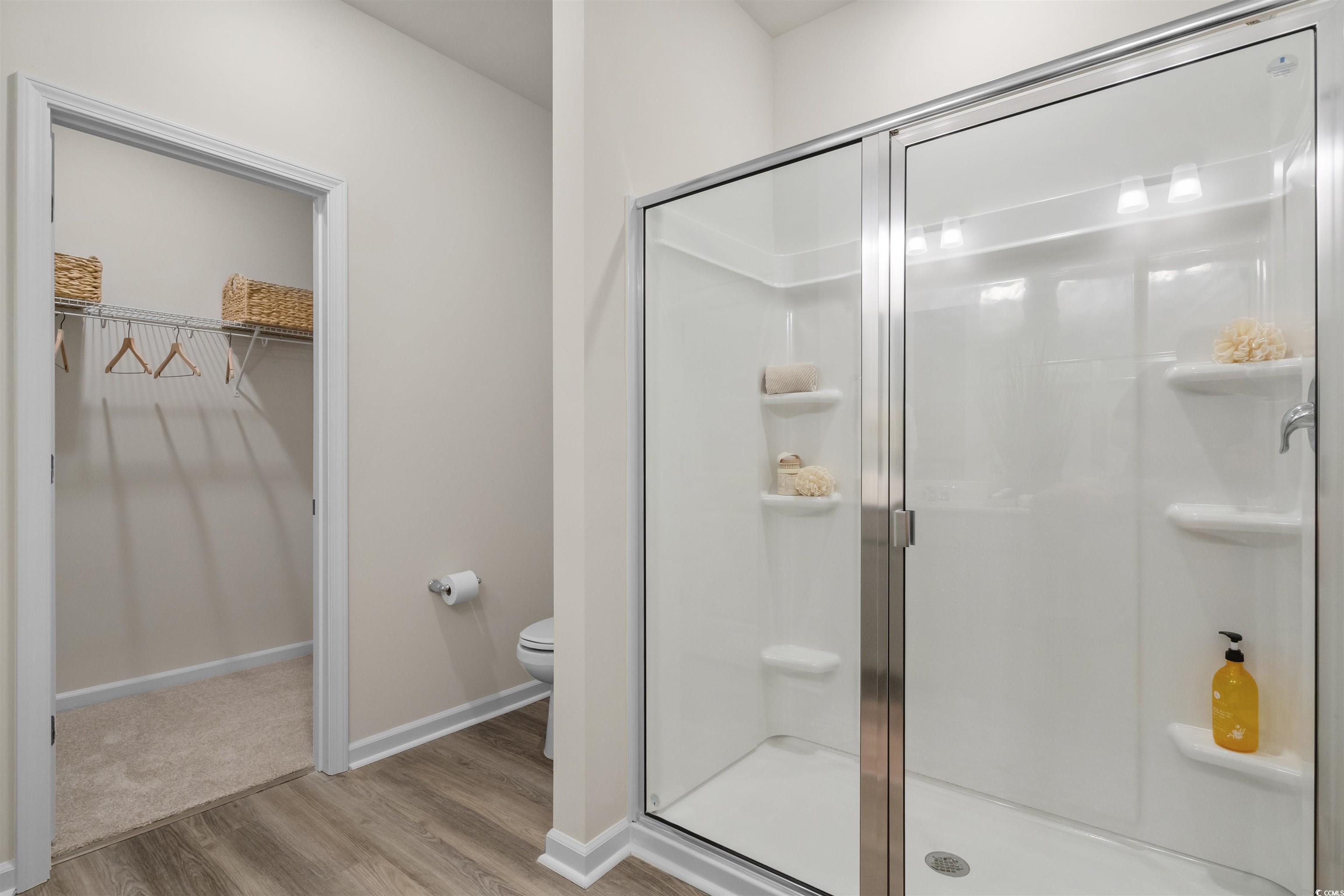 814 Palm Frond Way, Unit 42 Calabash, NC 28467 - Photo 16 of 31 Full bathroom featuring a spacious closet, a shower stall, and light LVP floors