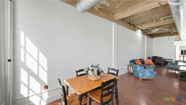 a kitchen with stainless steel appliances kitchen island granite countertop a refrigerator a stove and a dining table with wooden floor