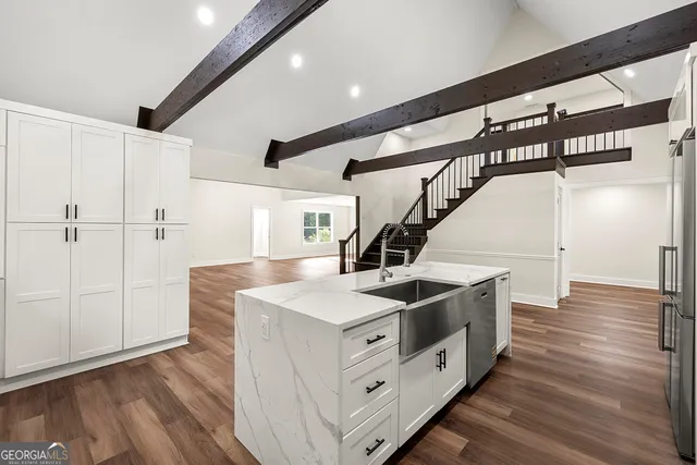 a kitchen with a sink and wooden floor