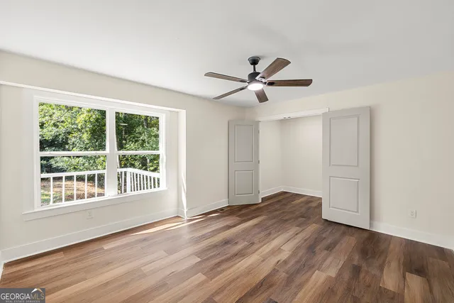 a view of a big room with wooden floor and windows