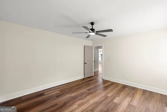 a view of a big room with wooden floor and a ceiling fan